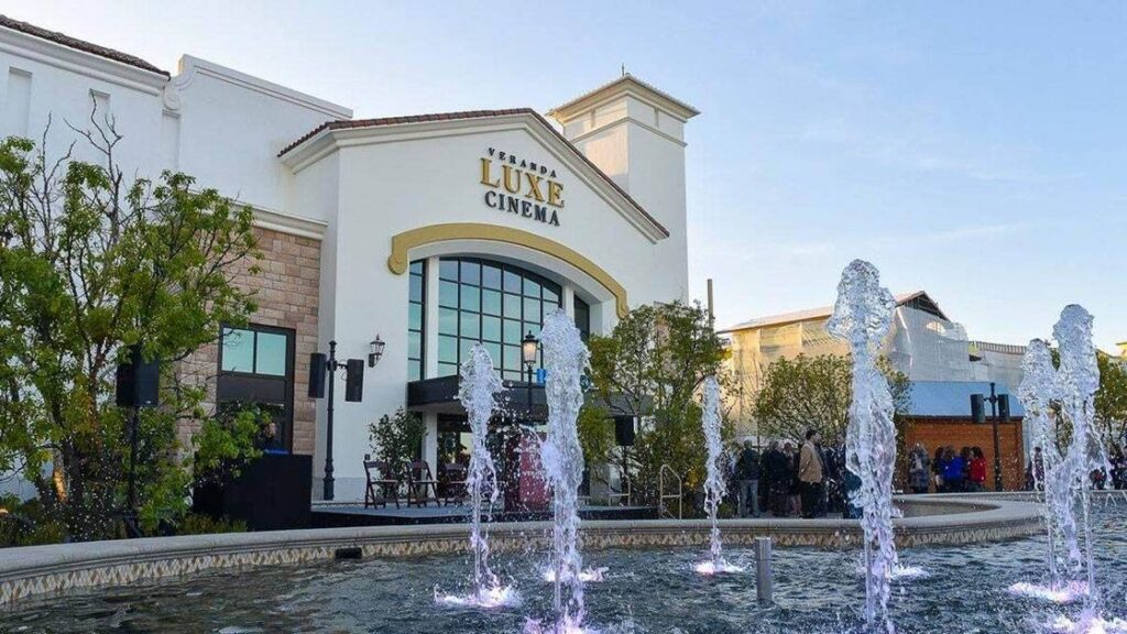 A movie theater with fountains in front of it