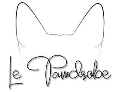 A minimalist logo featuring the outline of a cat's head with pronounced ears. Below the outline, the name 'Le Pawdrobe' is written in elegant, flowing script, emphasizing the cat theme of the branding.