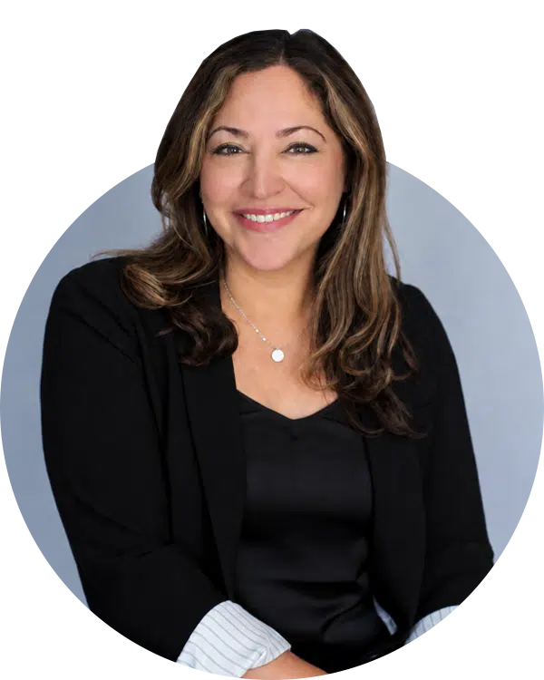 A smiling woman in a black blazer and top poses against a light blue oval background, with a Joybound donate items context for Giving Societies.