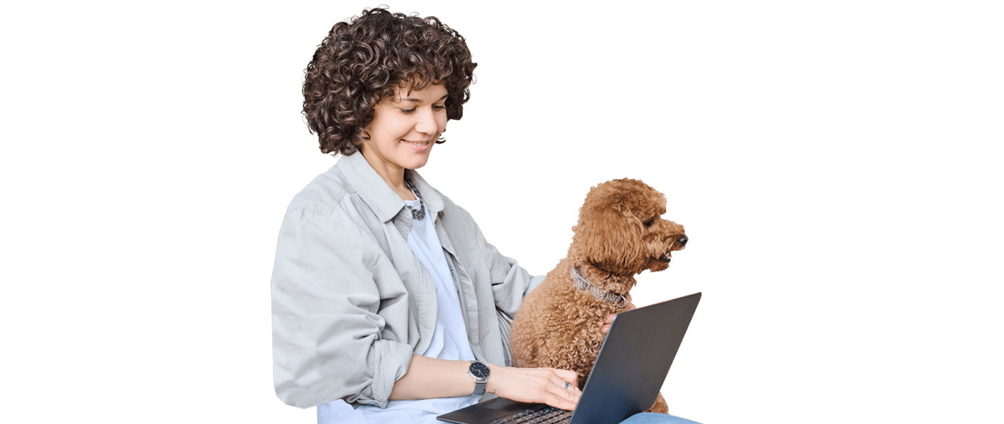 A woman with short curly hair works on a laptop beside a small brown dog, cut out against a white background, for Joybound.