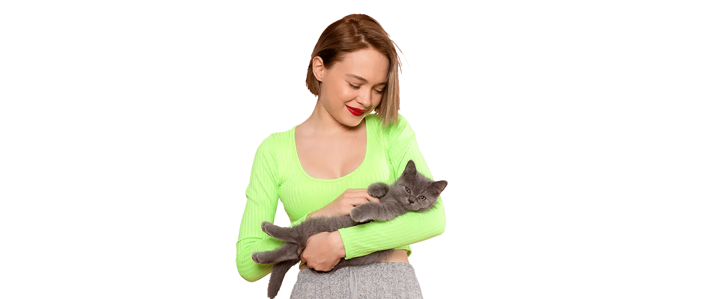 A woman in a bright green top holds a gray cat, representing Joybound, against a plain background.