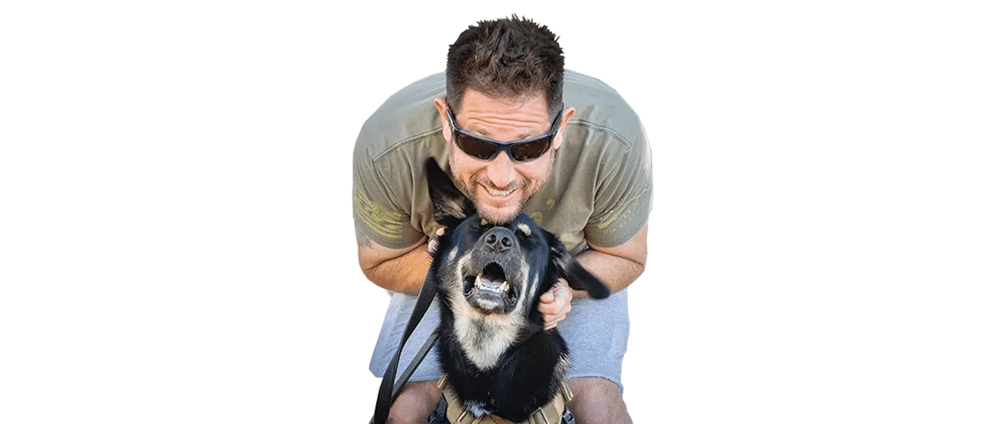 A man wearing sunglasses crouches behind a black-and-tan dog on a white background, illustrating service dog fostering.